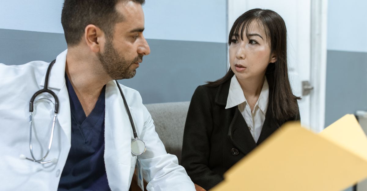 Médico e mulher em conversa em ambiente clínico