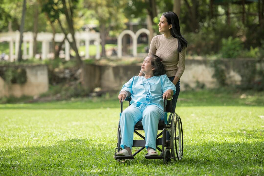 Cid g71 1 distrofia miotonica de steinert afastamento auxilio doenca e aposentadoria inline 2 508170 1785417392 Pessoa em cadeira de rodas sendo assistida por outra em um parque.