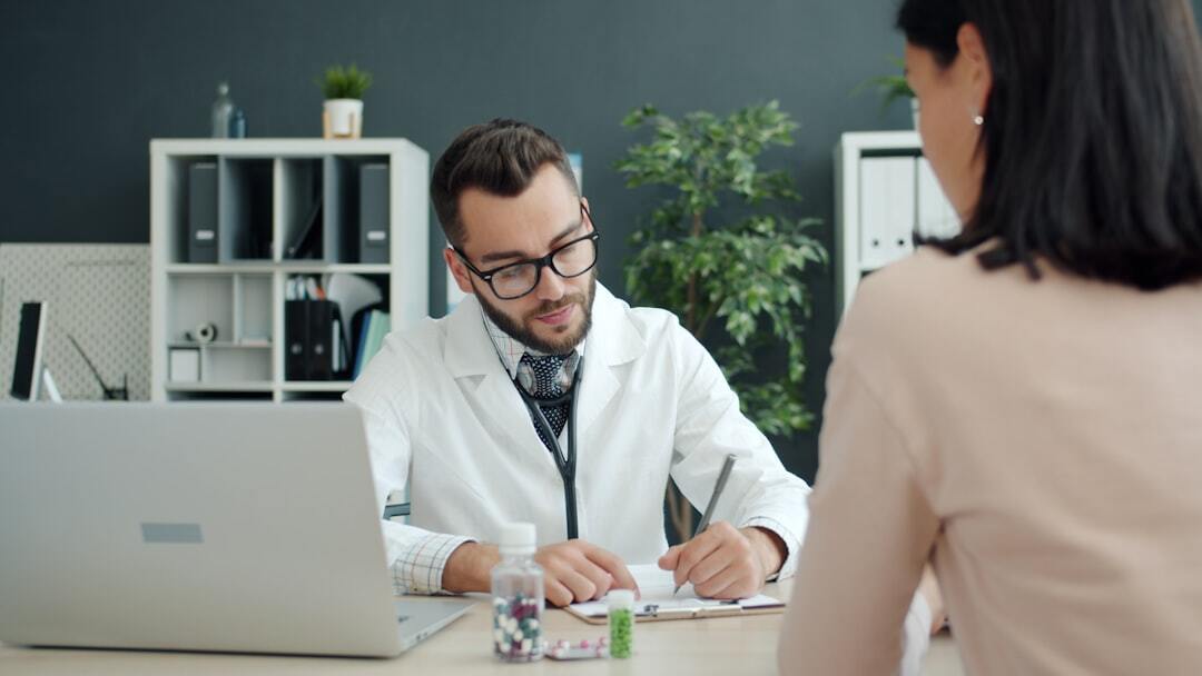 Médico e paciente em consulta, discutindo documentos em ambiente de escritório.