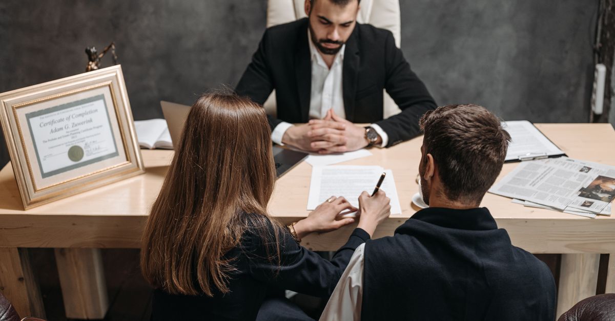 Colaboracao premiada inline 1 449487 1784576234 Advogado e clientes em reunião de escritório, discutindo documentos.
