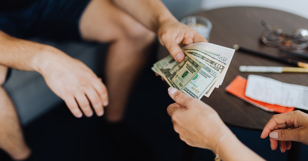 Concussao e excesso de exacao inline 1 468953 1784921673 Pessoas trocando dinheiro em uma mesa com documentos e objetos de escritório.