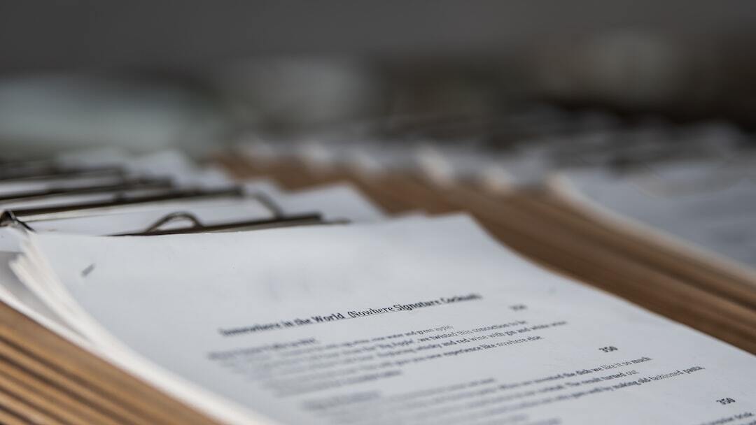 Pastas com documentos sobre licitações e contratos em uma mesa.