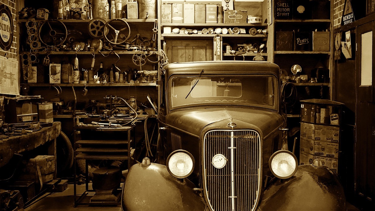 Devolucao de produto inline 2 429071 1784212843 Carro antigo em uma oficina mecânica vintage repleta de ferramentas e prateleiras ao fundo.