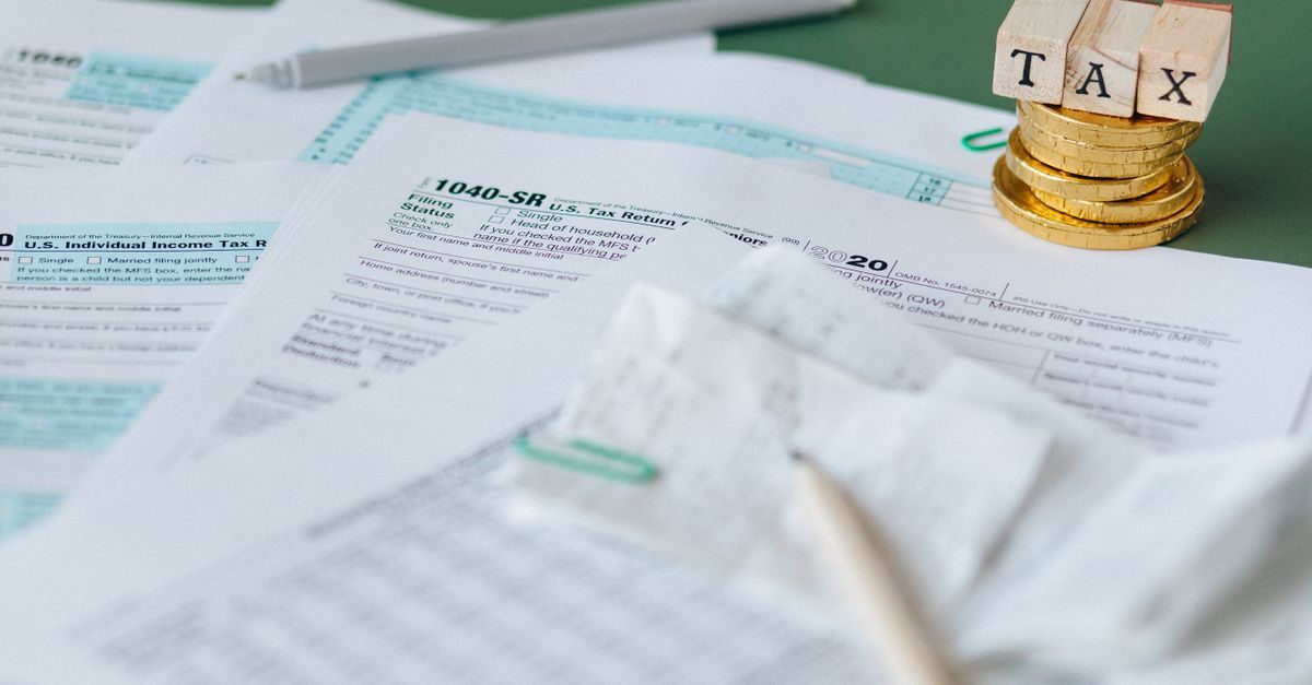 Papelada fiscal e moedas com a palavra 'tax' em cima. — foto: nataliya vaitkevich