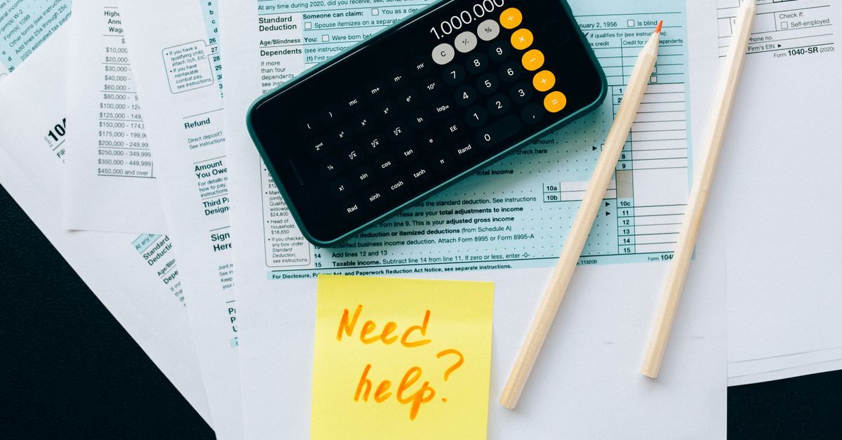 Leaving brazil for good the tax exit declaration and how to avoid penalties inline 2 508422 1785419187 Papelada com documentos e uma calculadora, com um post-it pedindo ajuda.