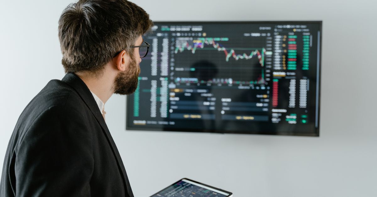 Piramides e fraude em investimentos inline 2 502160 1785354047 Homem em terno analisando gráficos financeiros em uma tela digital.