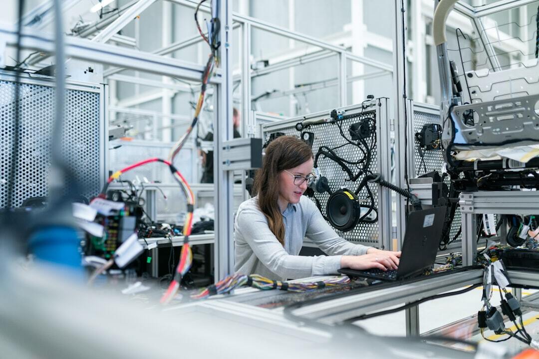 Brazil visa for technical assistance and foreign specialists inline 1 84069 1785861391 Mulher operando um laptop em um ambiente industrial com equipamentos técnicos ao redor.
