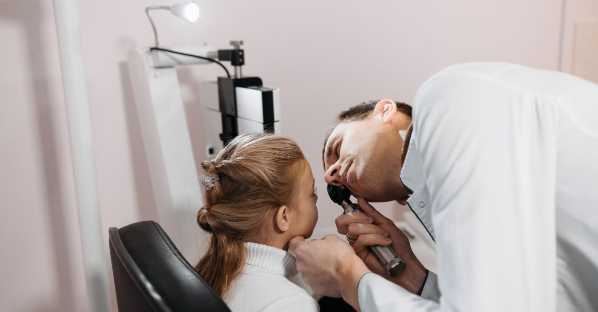 Profissional de saúde examinando uma criança em uma clínica médica.