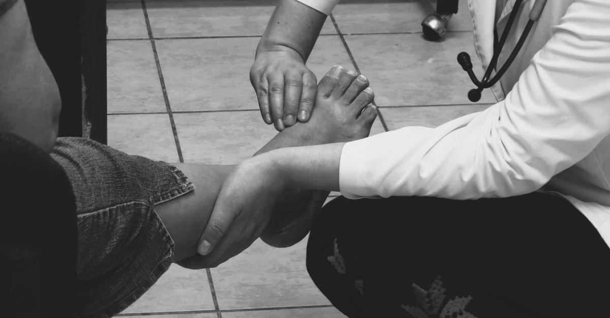 Cid i89 0 linfedema afastamento auxilio doenca e aposentadoria inline 1 663769 1787576786 Médico examinando o pé de um paciente, situando-se em um ambiente clínico.