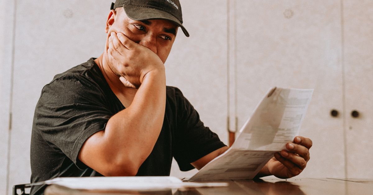 Cobranca indevida inline 1 420143 1786707358 Homem lendo documentos em uma mesa, com expressão de preocupação.