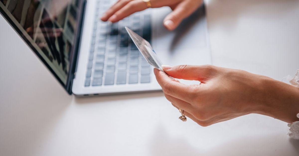 Codigo de defesa do consumidor inline 2 662625 1787484864 Mão segurando um cartão de crédito perto de um laptop, sugerindo transação online.