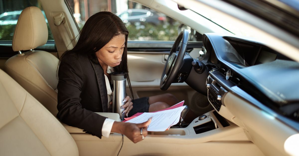 Crimes de transito inline 1 625317 1786795440 Mulher lendo documentos dentro de um carro, possivelmente relacionada a uma infração de trânsito.