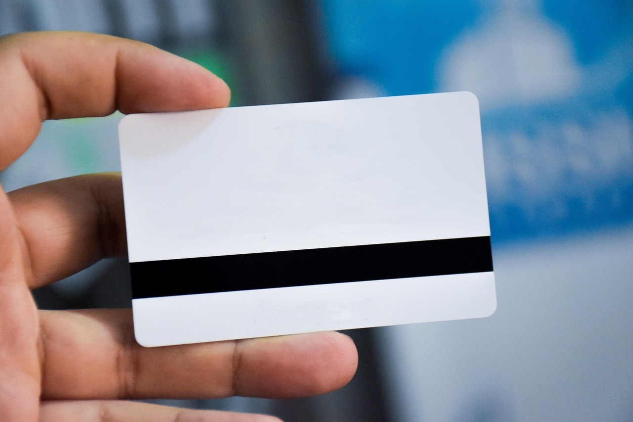 Crnm registration in brazil step by step guide for foreigners inline 1 617048 1786714508 Mão segurando um cartão branco com uma faixa negra, possivelmente um documento de identificação.