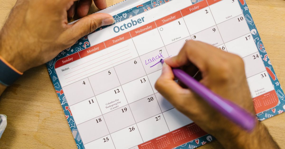 Ferias inline 1 637656 1786966535 Pessoa escrevendo em um calendário de outubro.