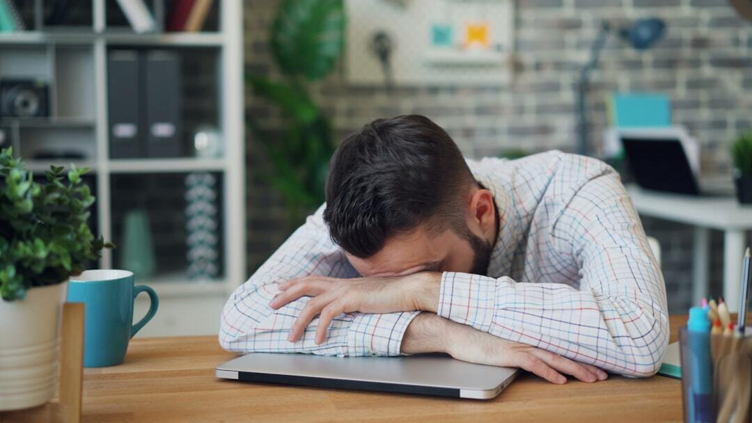 Ferias inline 2 637656 1786966547 Homem cansado em frente ao laptop, sugerindo necessidade de descanso e férias.