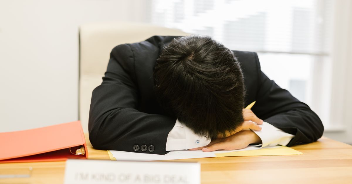 Hora extra inline 2 624223 1786786508 Homem cansado em uma mesa com documentos, sugerindo esforço excessivo