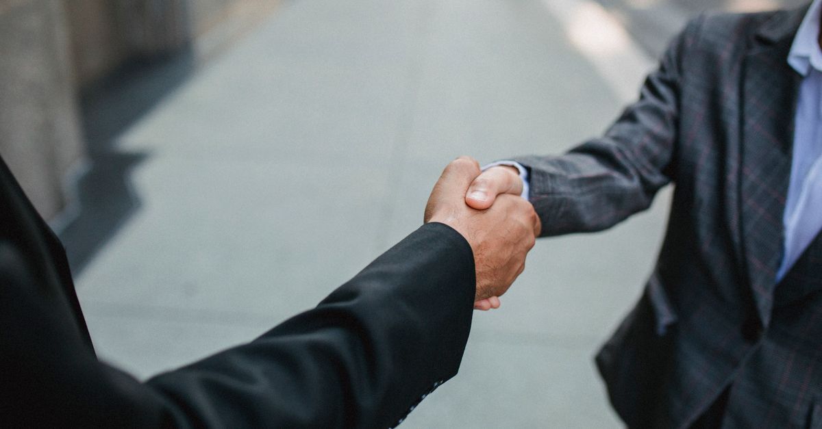 International arbitration in brazil inline 2 646177 1787070904 Duas pessoas em trajes profissionais apertando mãos em um ambiente externo.