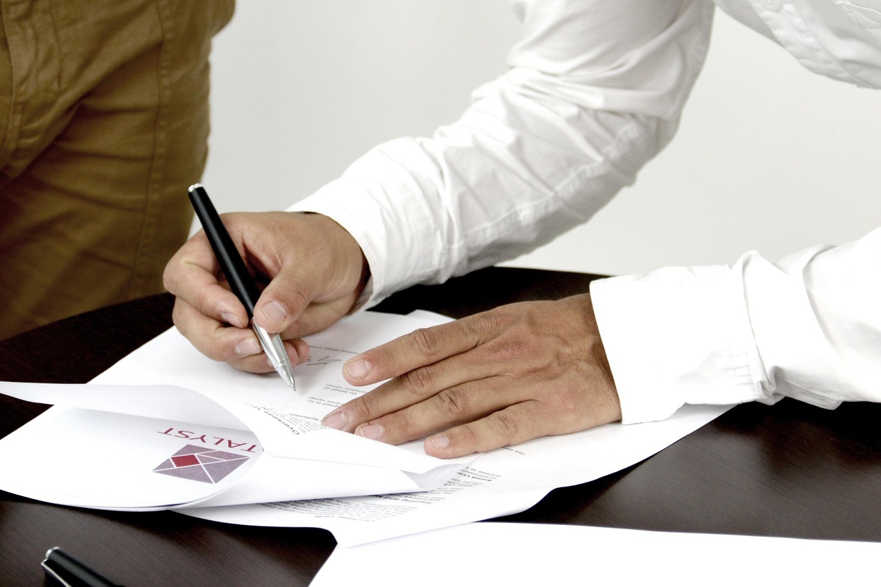 Inventario e partilha inline 1 369997 1786181763 Pessoa assinando documentos em uma mesa, representando a ação de inventário e partilha.