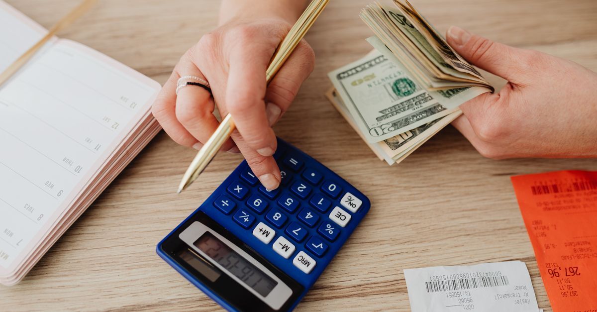 Legal costs in brazil court fees lawyer fees and when legal aid applies inline 1 604322 1786541691 Pessoa calculando valores em uma calculadora, com dinheiro e documentos em uma mesa.