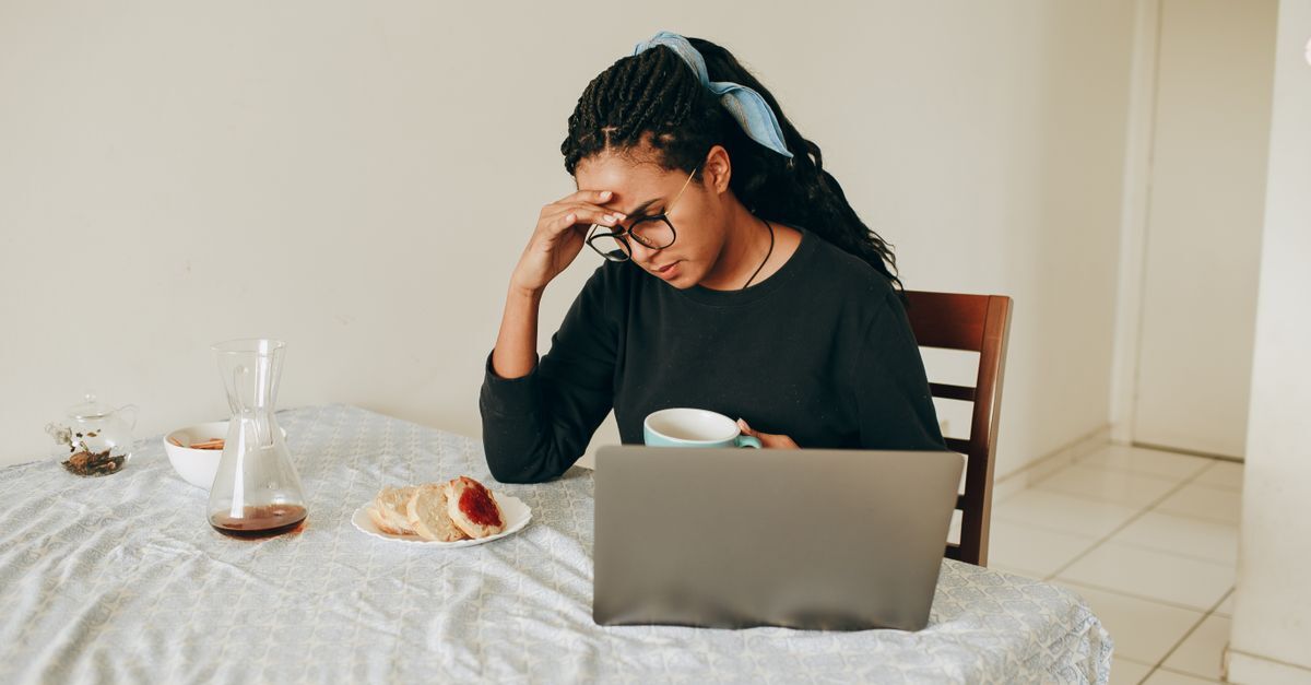 Uniao estavel inline 1 269 1786268168 Mulher sentada à mesa com um laptop, comendo e segurando uma xícara, em uma situação que pode refletir a falta de reconhecimento formal de sua situação.